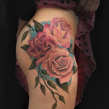 Color tattoo on a womans hip roses ibiza
